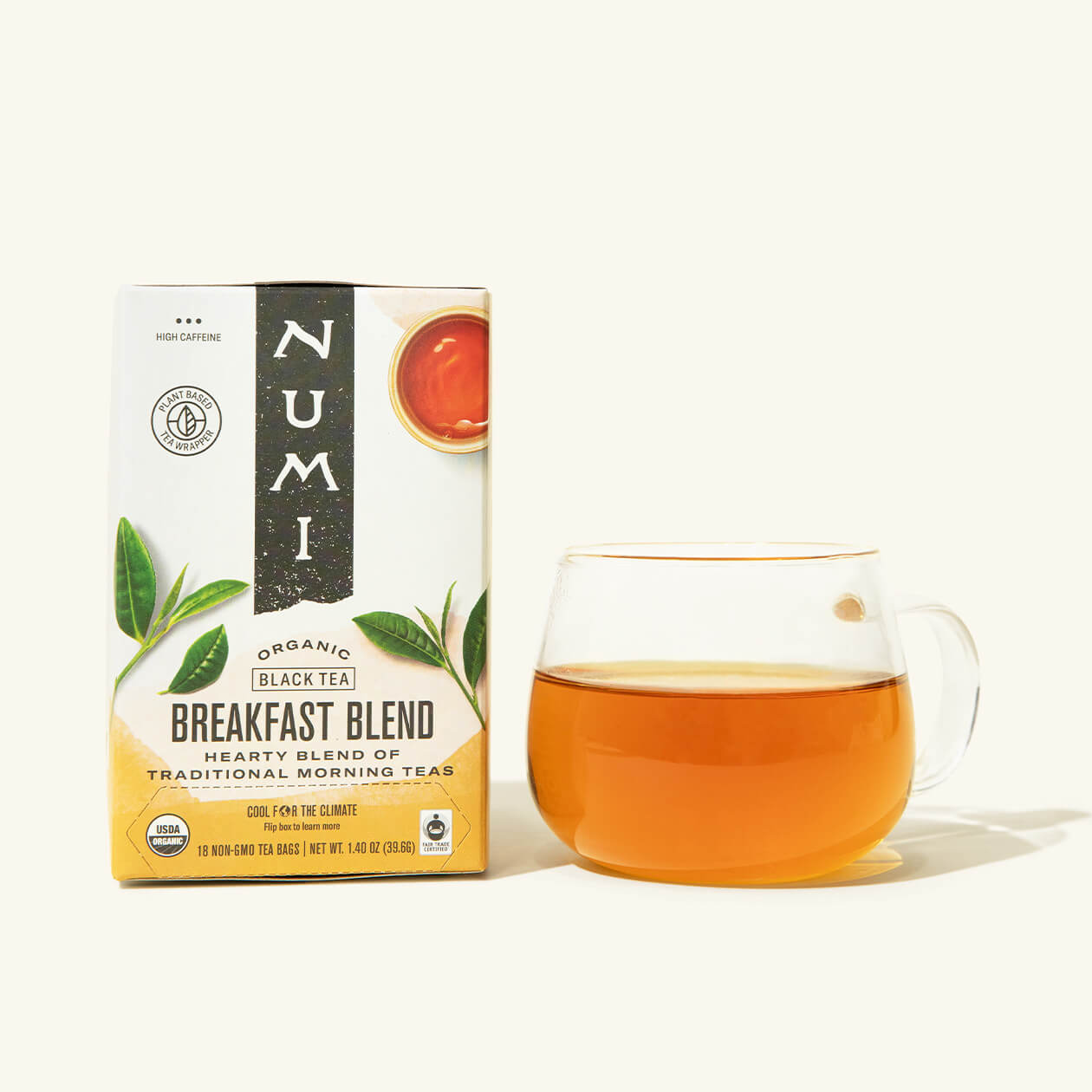 A box of Numi's Breakfast Blend tea next to a brewed cup of tea in a clear cup