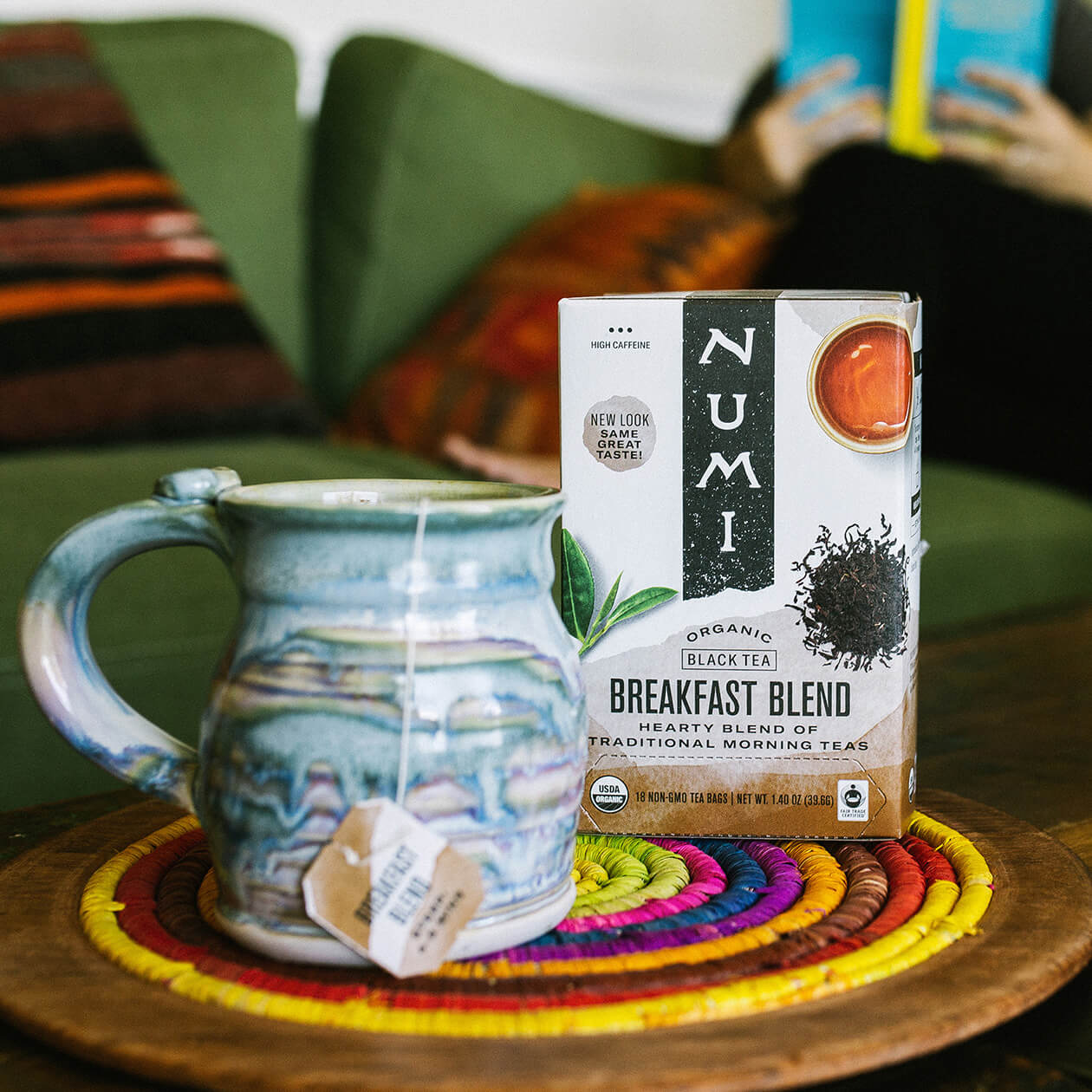 A hot cup of Numi Breakfast Blend Tea next to a handmade pottery cup