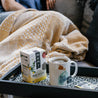 A person sitting on a couch enjoying a cup of Dandelion Detox tea