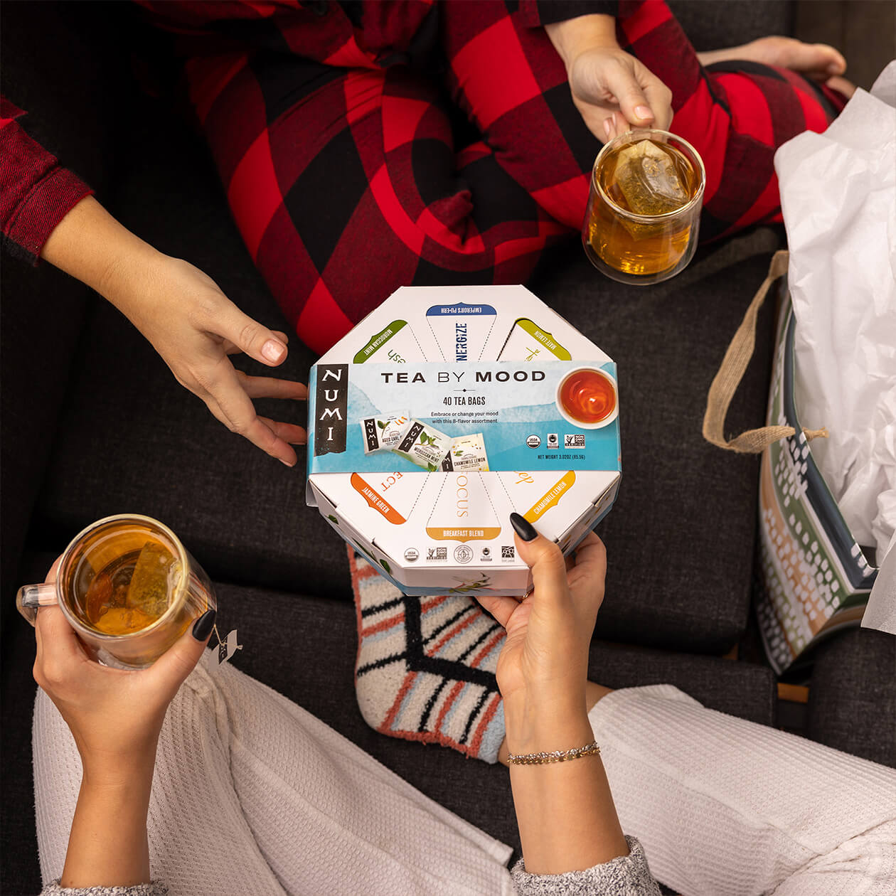 Two people enjoying tea exchanging a Tea By Mood gift