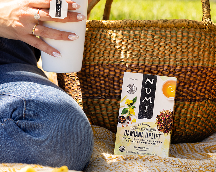 A person enjoys a cup of Numi&#39;s Damiana Uplift tea at a picnic