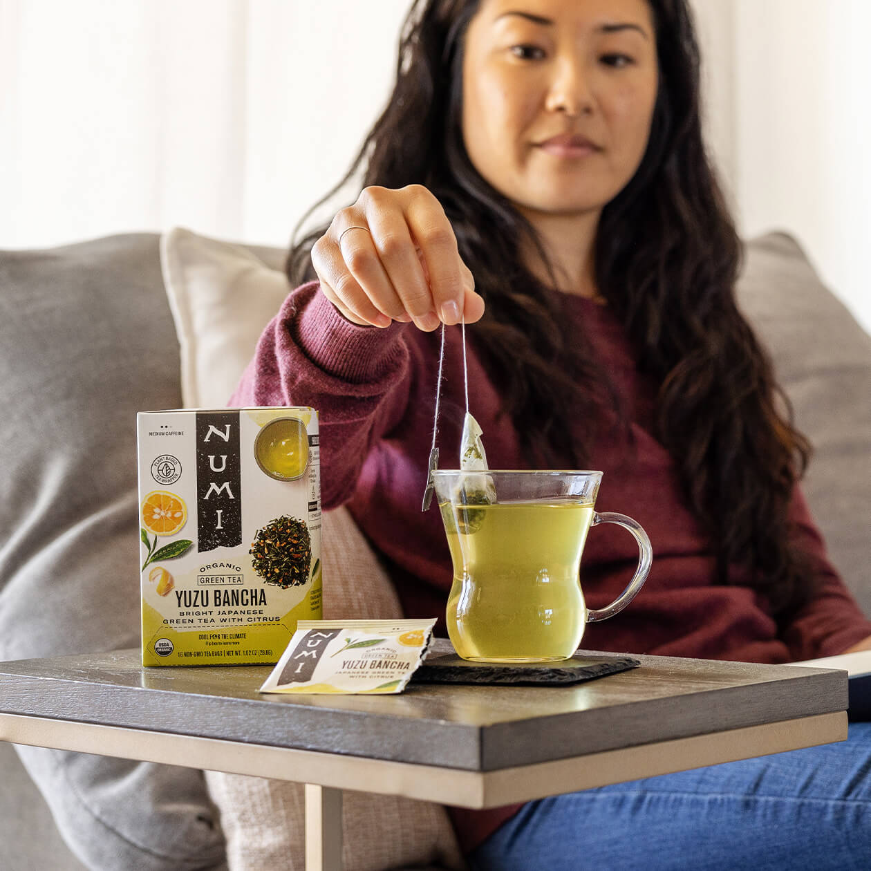 A woman enjoying a cup of hot Yuzu Bancha tea